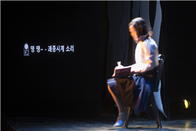 무대 위에 의자에 앉아 글을 읽는 모습 무대 위에 의자에 앉아 글을 읽는 모습