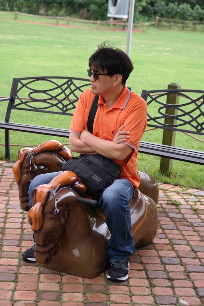 말 모양의 의자에 앉아있는 이상훈 사진