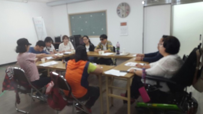 회의테이블에 앉아서 회의를 진행하는 모습