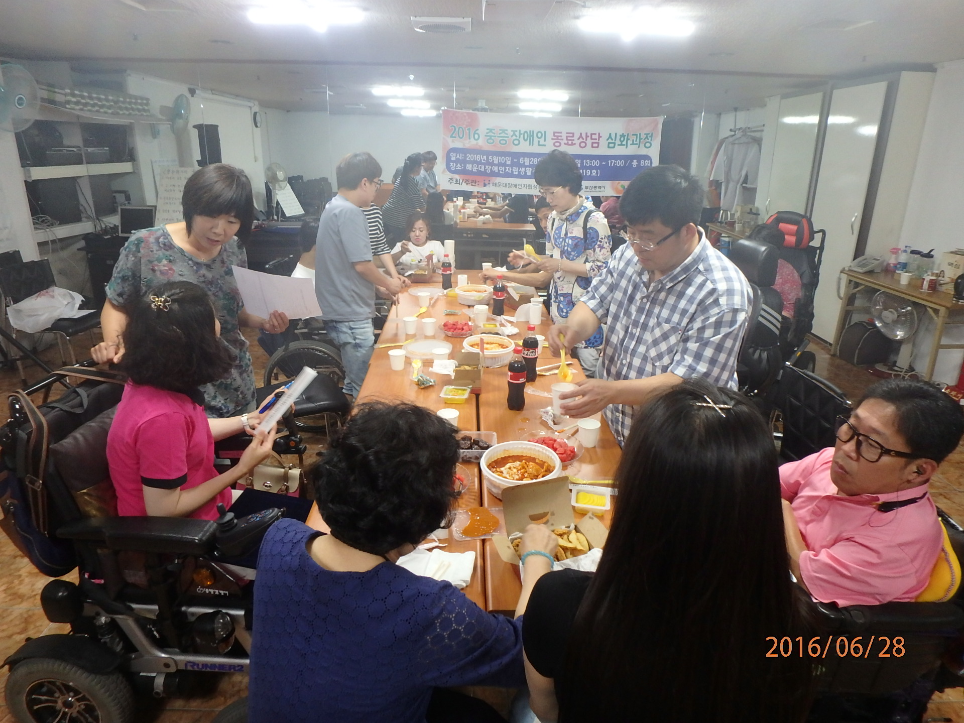 교류회 사진(다 같이 모여 앉아, 치킨과 떡볶이, 음료수를 맛있게 먹는 모습)
