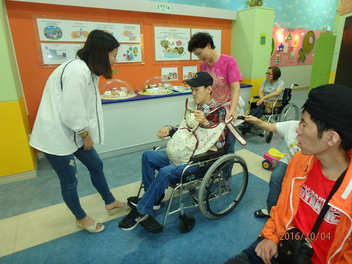 김자운씨가 휠체어를 탄체 임산부 체험벨트를 체험 해보는 사진