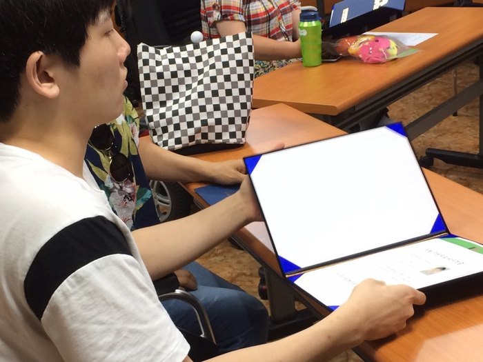 박성민씨가 동화구연 자격증을 받아들고 있는 사진