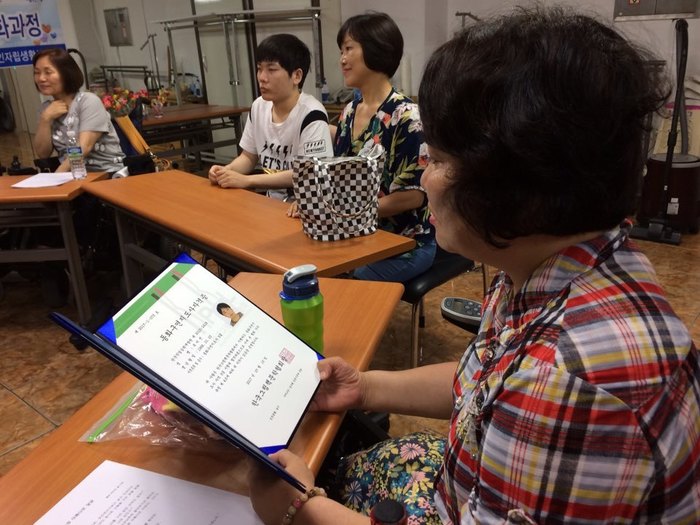 추미선씨가 동화구연 지도사 자격증을 받아들고 보고 있는 사진