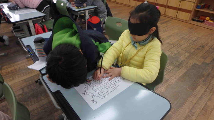 안대를 한친구에게 미로찾기를 설명을하고 있는 모습 안대를 한친구에게 미로찾기를 설명을하고 있는 모습