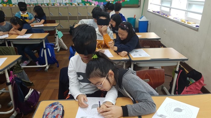 안대 쓴 친구에게 미로를 설명하고 있는 모습 안대 쓴 친구에게 미로를 설명하고 있는 모습