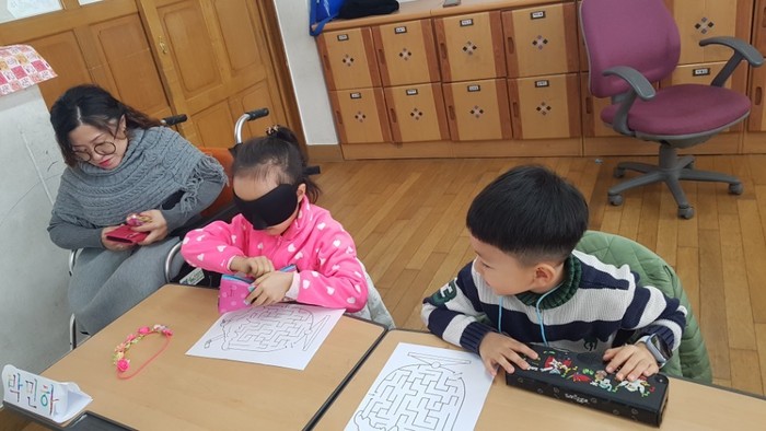 안대를 쓴 김윤정 강사에게 미로를 설명하는 학생모습 안대를 쓴 김윤정 강사에게 미로를 설명하는 학생모습