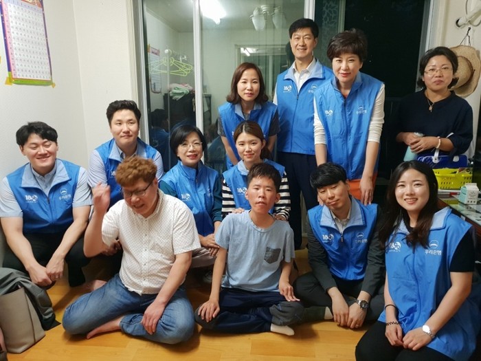 일을 끝낸 9명의 은행직원들과 체험 홈 입주자 김자운, 김기한씨가 함께 찍은 사진
