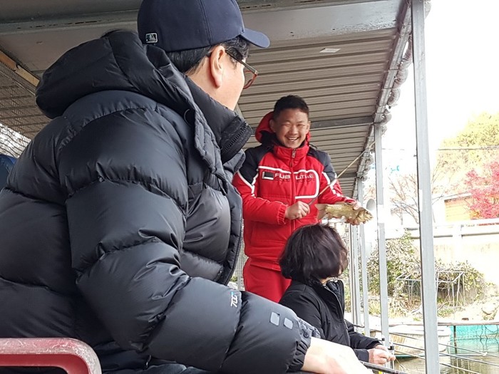 김태우 입주자가 큼직한 붕어를 낙아올려 손으로잡고 활짝 웃고 있는 사진