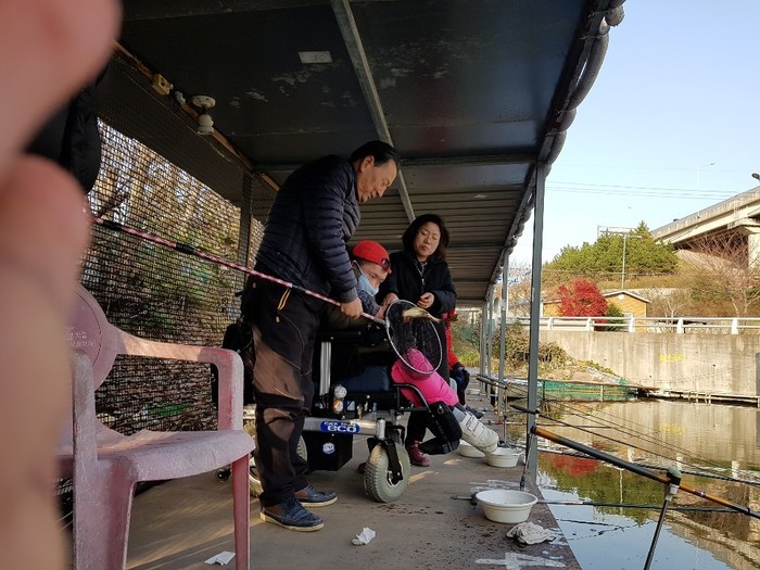 낚시터 사장이 큰 붕어를 잡아 전연식씨에게 보여주는 사진