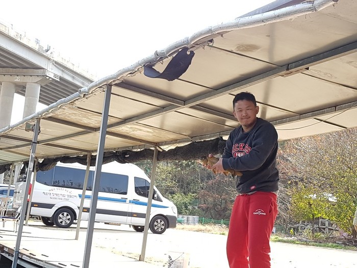 김태우씨가 잡은 큼직한 붕어를 손으로 잡고 찍은 사진