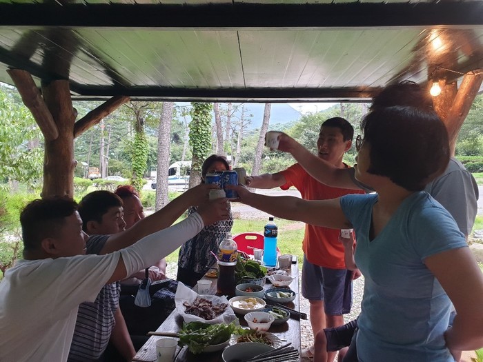 저녁 먹으며 캔 맥주 건배하는 사진