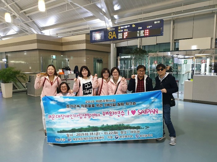 공항 안에서 현수막 앞 단체사진 공항 안에서 현수막 앞 단체사진