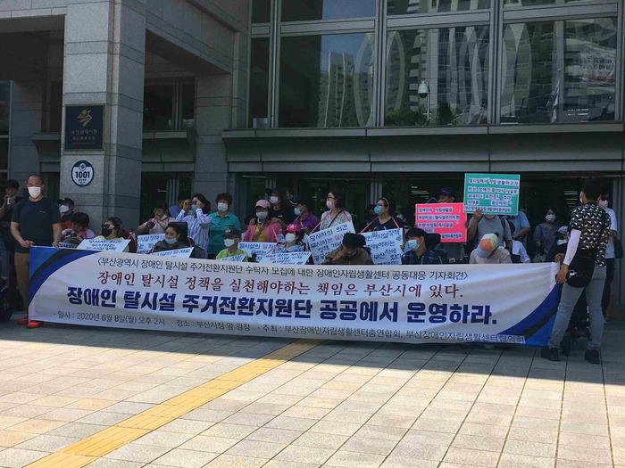 탈시설주거전환지원 수탁기관 규탄 현수막 아래에 모두모인 연대단위들 모습 탈시설주거전환지원 수탁기관 규탄 현수막 아래에 모두모인 연대단위들 모습