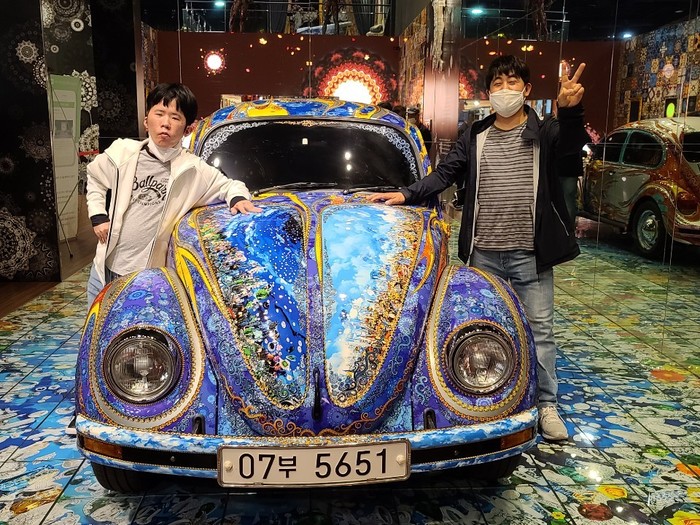 자동차 앞에 서 있는 김자운님과 김정민님 자동차 앞에 서 있는 김자운님과 김정민님