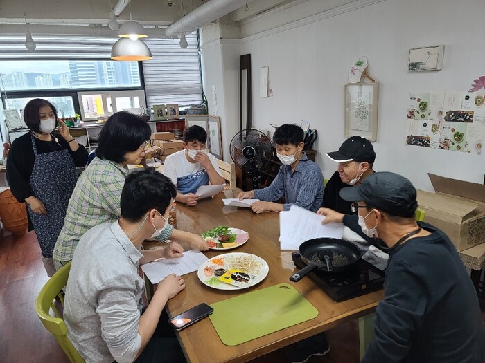 테이블에 둘러 앉아 강사님으로 부터 재료 설명을 듣고 있는 마리원 식구들 테이블에 둘러 앉아 강사님으로 부터 재료 설명을 듣고 있는 마리원 식구들