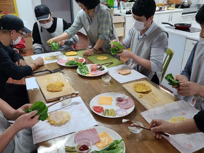 각자 원하는 재료들을 밥 패디위에 올리고 있는 마리원 식구들 각자 원하는 재료들을 밥 패디위에 올리고 있는 마리원 식구들