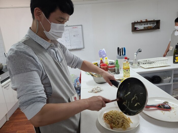 완성된 볶음 우동을 접시에 담고 있는 정신우씨 완성된 볶음 우동을 접시에 담고 있는 정신우씨