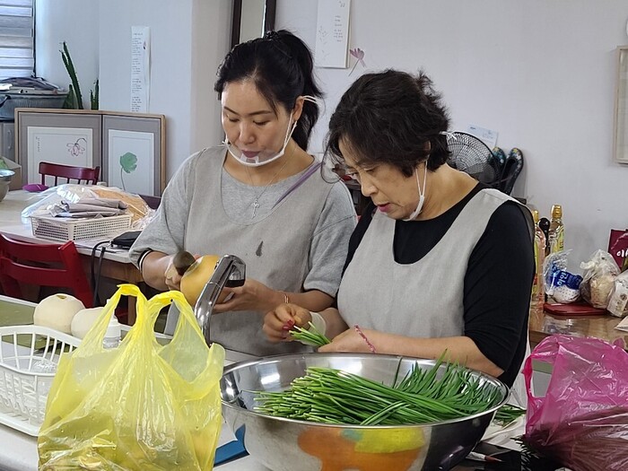 재료 손질 (부추 다듬기, 배 깎기)을 하고 있는 사진 재료 손질 (부추 다듬기, 배 깎기)을 하고 있는 사진