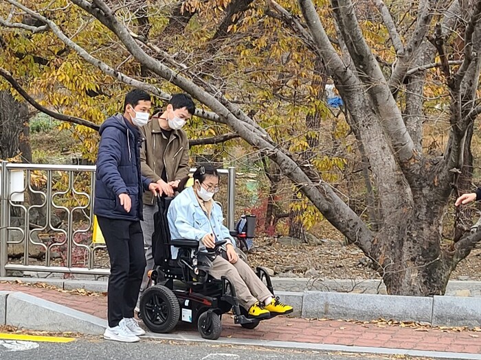휠체어를 타고있는 전지현님과 함께 걷고 있는 정신우, 박정우님 휠체어를 타고있는 전지현님과 함께 걷고 있는 정신우, 박정우님