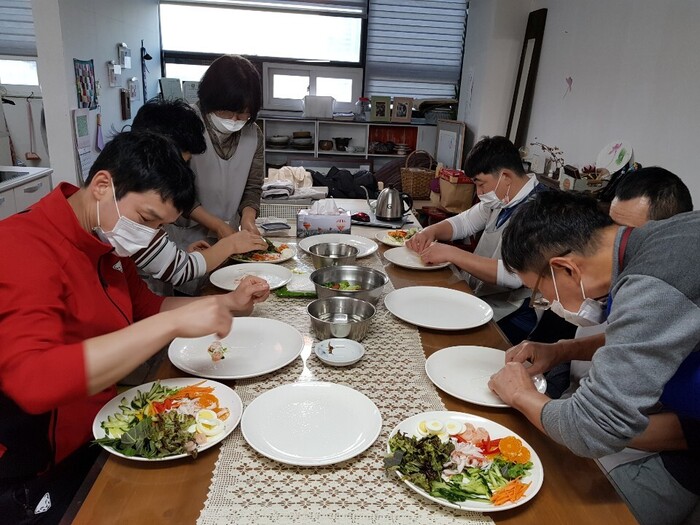 라이스페이퍼에 재료 넣고 있는 마리원 식구들 라이스페이퍼에 재료 넣고 있는 마리원 식구들