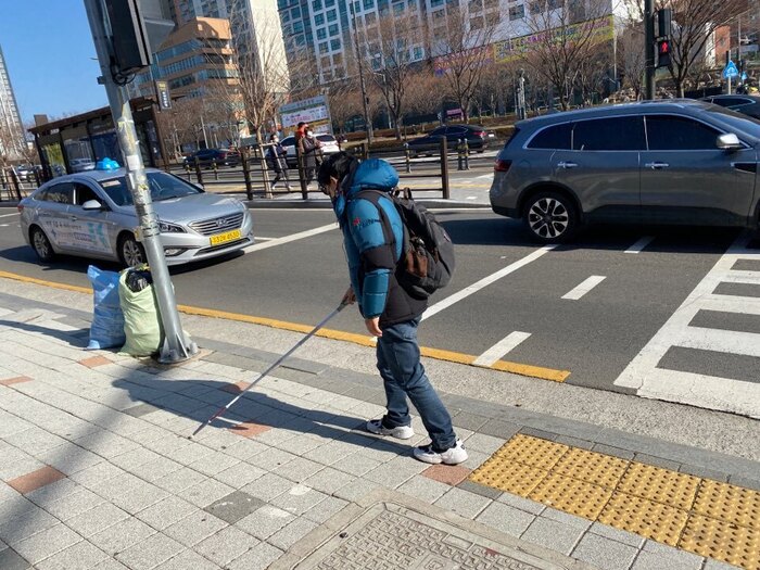 건널목 가장자리에 설치되어 있는 점자블록과 상당한 거리에 위치한 음향신호기 모습 건널목 가장자리에 설치되어 있는 점자블록과 상당한 거리에 위치한 음향신호기 모습