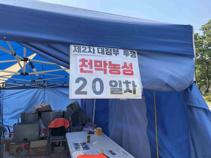 천막 입구 앞 제2차 대정부 투쟁 천막농성 20일차가 적혀 있음. 천막 입구 앞 제2차 대정부 투쟁 천막농성 20일차가 적혀 있음.