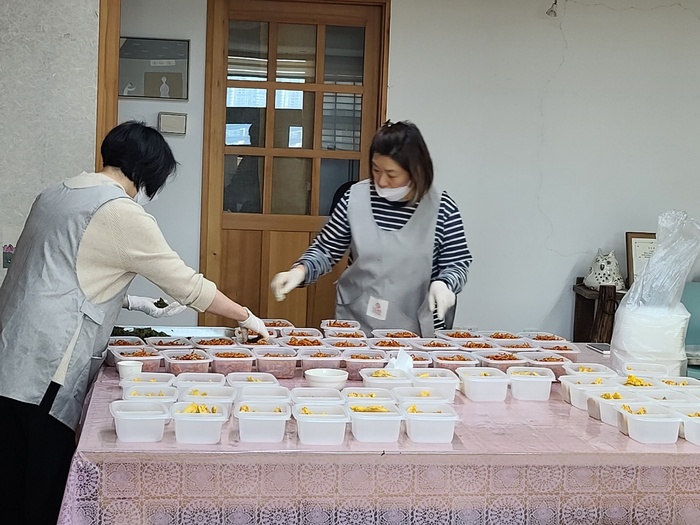 일회용 용기에 음식을 담는 자원봉사자 사진 일회용 용기에 음식을 담는 자원봉사자 사진