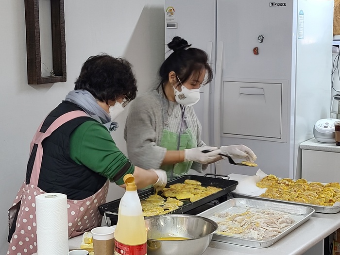 동태전을 굽고 있는 자원봉사자들 동태전을 굽고 있는 자원봉사자들
