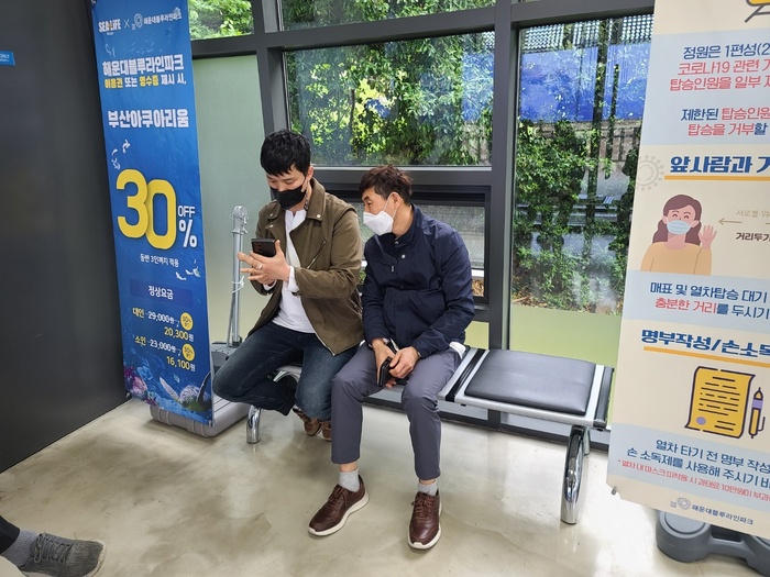 정신우씨와 김성철씨가 같이 앉아 휴대폰을 보는 사진 정신우씨와 김성철씨가 같이 앉아 휴대폰을 보는 사진