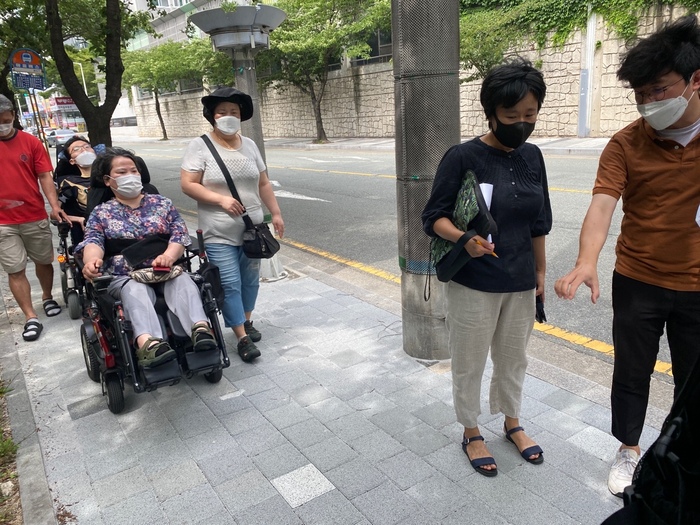 보도를 이동하면서 해운대구청 관계자의 말을 듣고 있는 모습 보도를 이동하면서 해운대구청 관계자의 말을 듣고 있는 모습