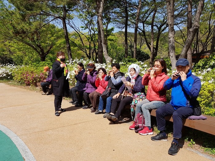 소나기회원들 대천공원 벤치에 앉아서 오카리나 연주하는 모습