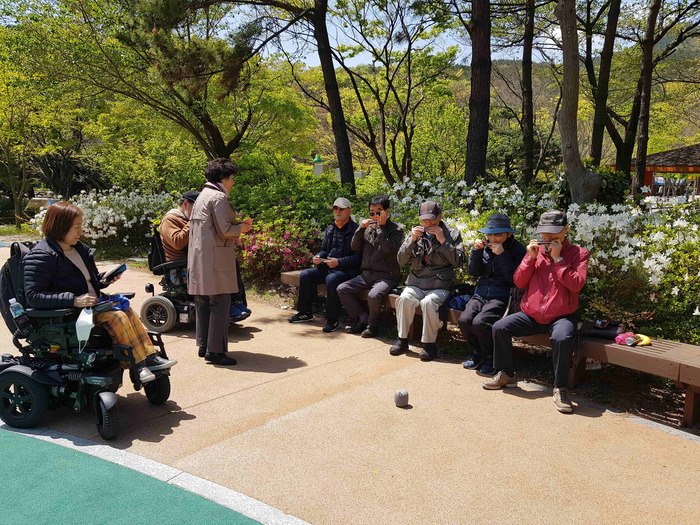 장산 대천 공원에서 하늘소 회원들 하모니카 수업 하는 모습