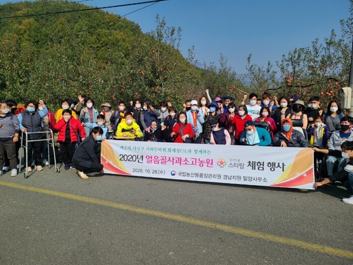 사과밭 앞에서 현수막을 들고 단체사진을 찍고 있는 모습 사과밭 앞에서 현수막을 들고 단체사진을 찍고 있는 모습